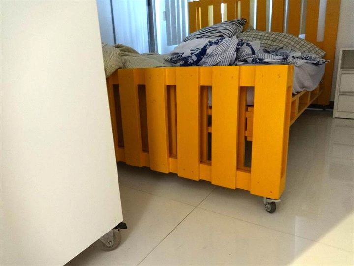 yellow painted pallet bed on wheels